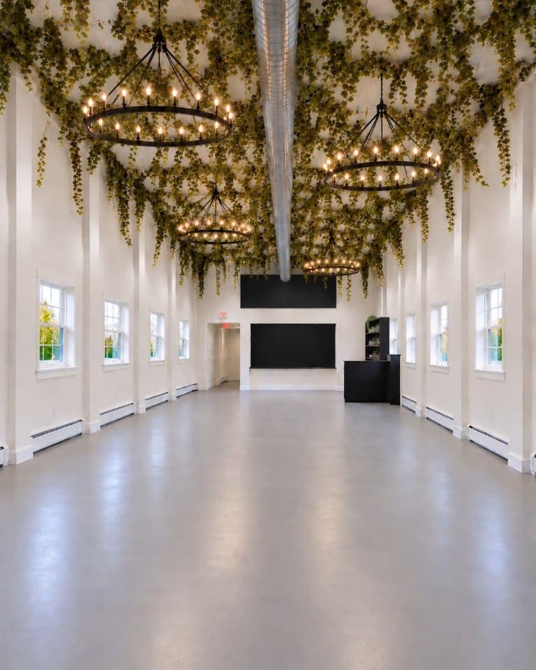 The reception hall at Aria Venue, with ring chandeliers and ivy along the ceiling